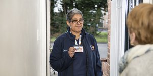 Woman standing in doorway showing her staff pass