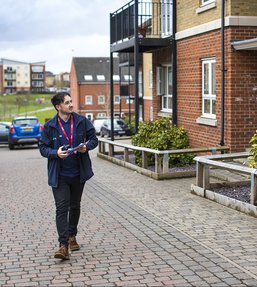 Man walking past houses