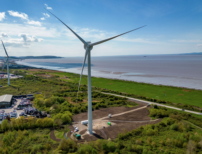 Two wind turbines next to the sea