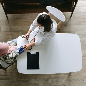 Doctor measuring a patient’s blood pressure during a routine health check-up