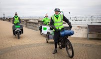 Three people on bikes with high vis on, operating a low carbon courier service