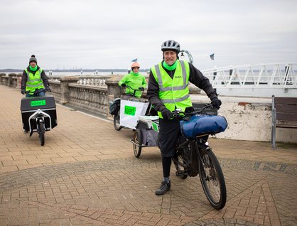 Three people on bikes with high vis on, operating a low carbon courier service