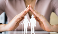 Image of a pair of hands forming a roof, with the silhouettes of an elderly couple superimposed below