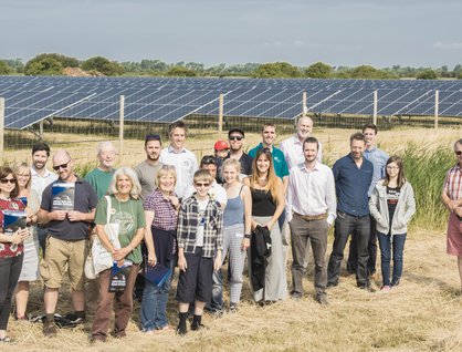 Group of people stood infront of a solar panel