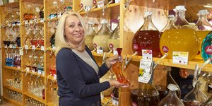 Woman smiling and holding a shoe shaped bottle of alchol