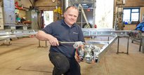 Man working on an axel for a trailer
