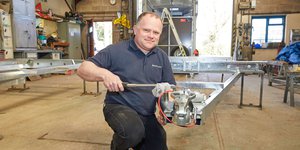 Man working on an axel for a trailer