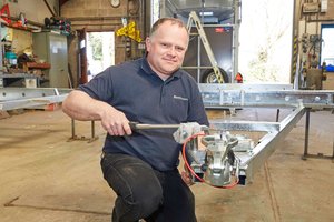 Man working on an axel for a trailer