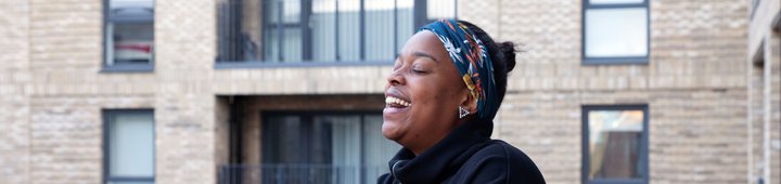 Woman smiling on balcony at Campbell Wharf, looking out
