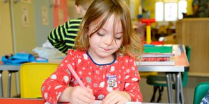 Young girl drawing in a classroom