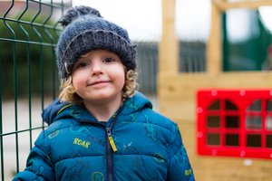 Young boy wearing a blue beanie and coat