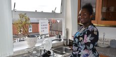 Women standing at her sink, looking the camera and smiling