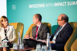 A woman and two men sitting on a panel