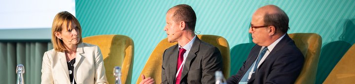 A woman and two men sitting on a panel
