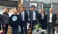Six people, including Ed Miliband MP, at a scrap works smiling to the camera
