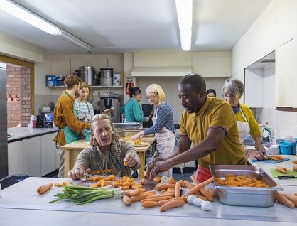 Images of a group of 8 people helping to prepare food in an industrial kitchen
