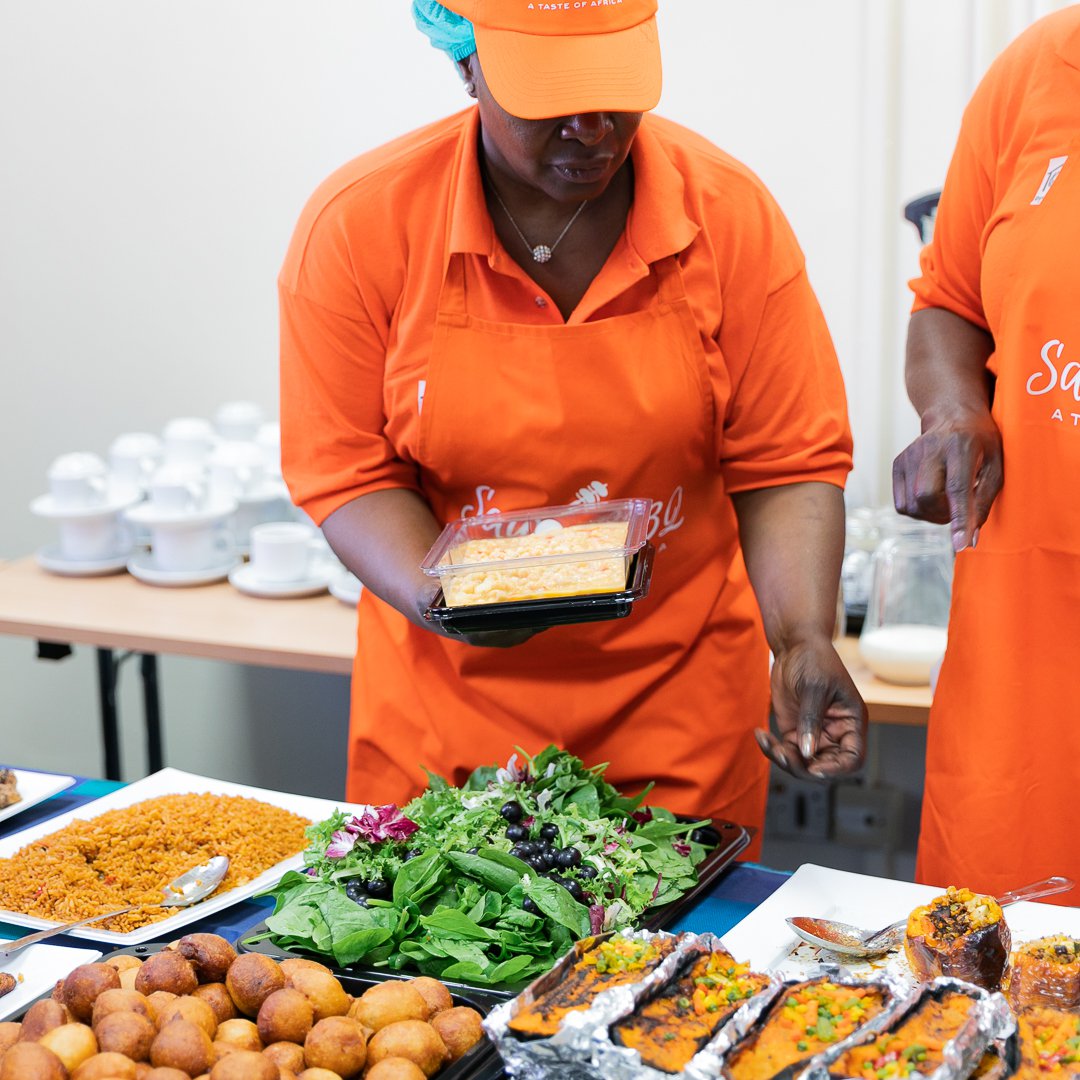 Woman in orange apron serving food