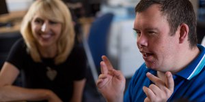 Man with a learning disability talking with his carer