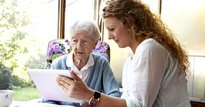 Carer sitting with an elderly woman