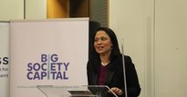 Rushanara Ali MP speaking at a lectern in front of a pop up banner which says 'Big Society Capital - Uniting capital, expertise and ideas for better lives'