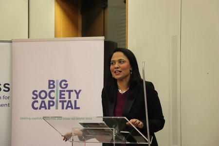 Rushanara Ali MP speaking at a lectern in front of a pop up banner which says 'Big Society Capital - Uniting capital, expertise and ideas for better lives'