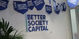 Better Society Capital logo on wall and blue bunting