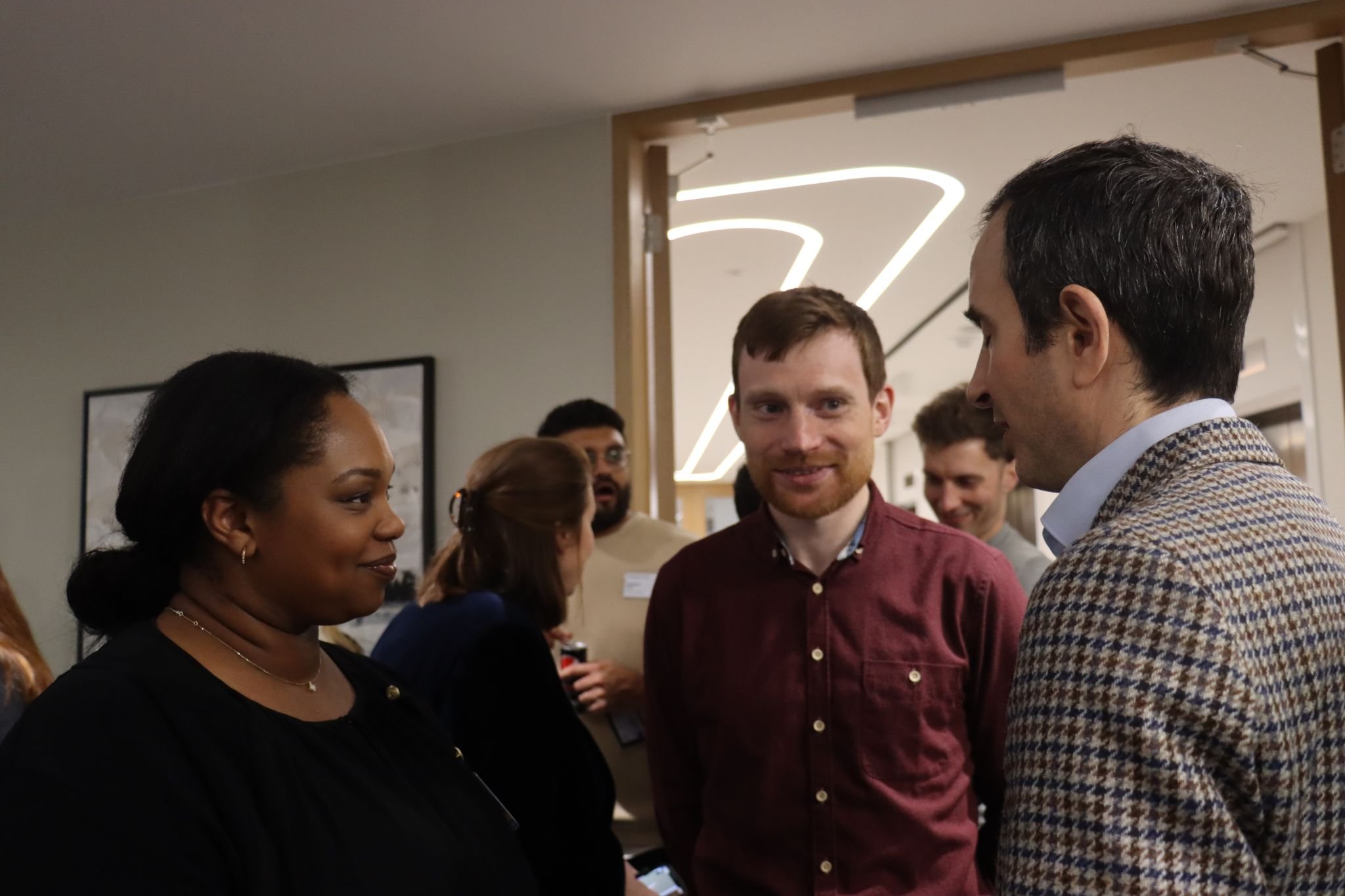 Three people in discussion at a networking event