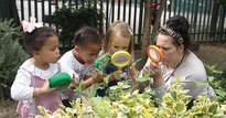 Three children looking through magnifying glasses
