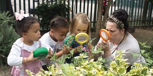Three children looking through magnifying glasses
