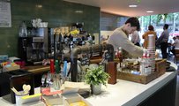 Worker at social enterprise cafe, Open Kitchen making coffee