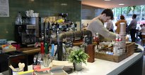 Worker at social enterprise cafe, Open Kitchen making coffee
