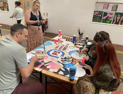 Group of people sitting around a table painting