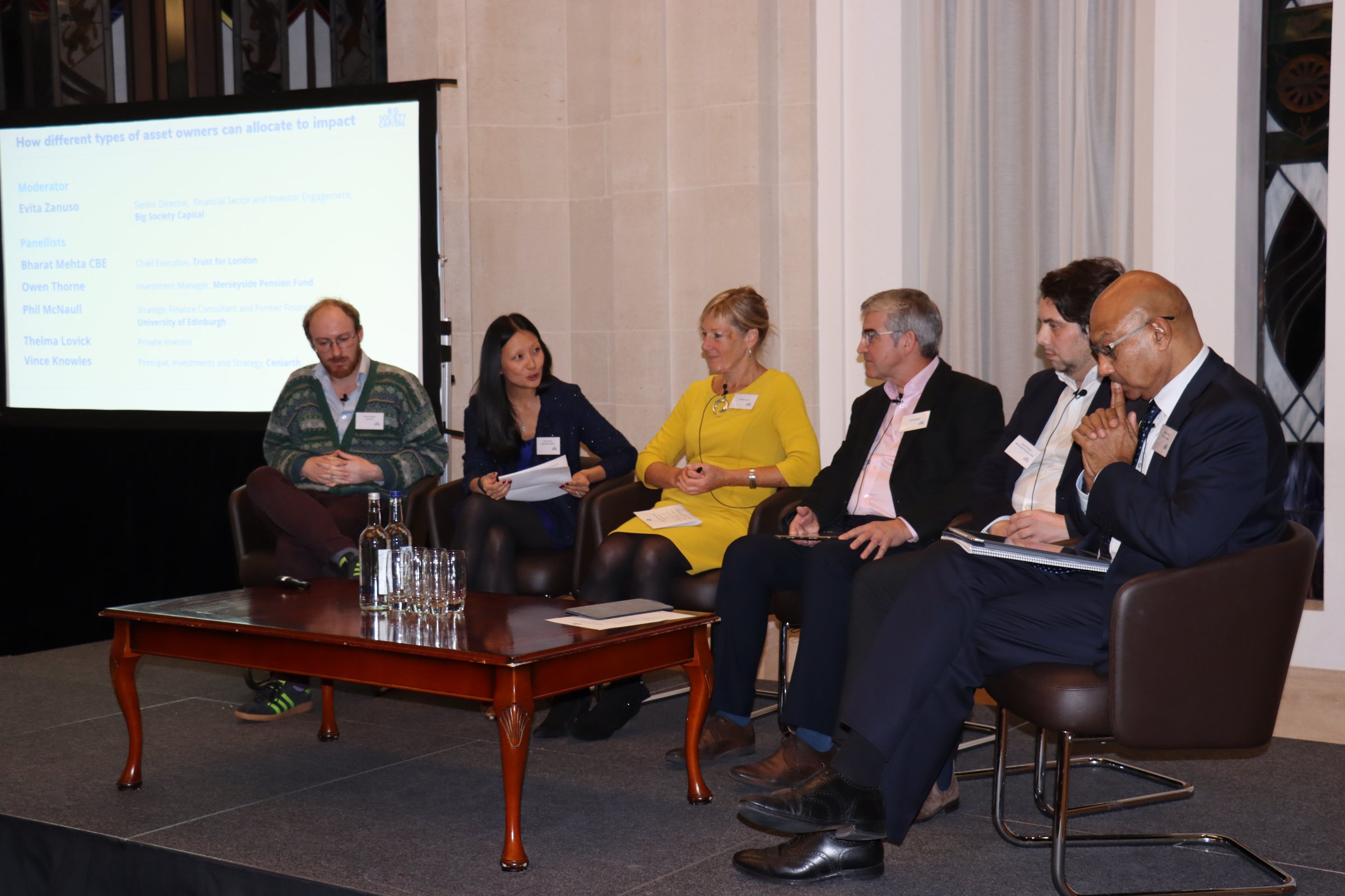 Six people sat on a panel having a discussion