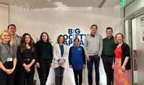 Members of BSC standing with a member of Clean for Good's staff in front of the organisation's logo