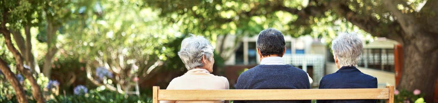 Three elderly people sat on a bench