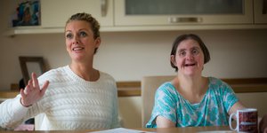 A woman with a learning disability smiling with their carer