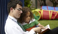 Man reading a book with a child