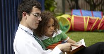 Man reading a book with a child