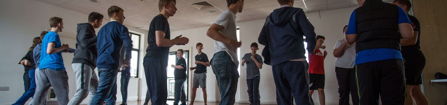 Group of young people standing in a circle in a sports hall