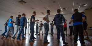 Group of young people standing in a circle in a sports hall