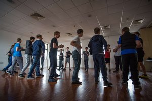 Group of young people standing in a circle in a sports hall