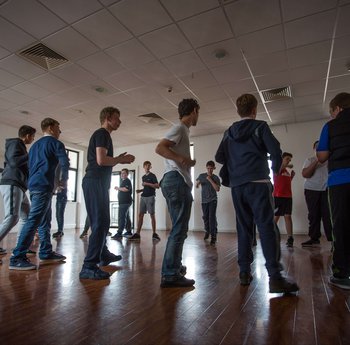 Group of young people standing in a circle in a sports hall