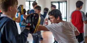 Two young boys boxing in a sports hall
