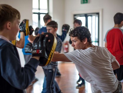 Two young boys boxing in a sports hall