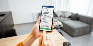 Hands holding a phone showing the Switchee app interface