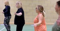 Four women exercising in a leisure centre hall