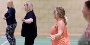 Four women exercising in a leisure centre hall