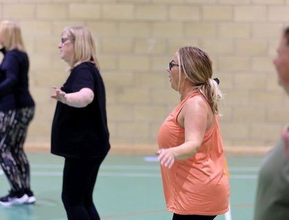Four women exercising in a leisure centre hall