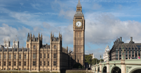 Image of ornate buildings including large clock tower from across a river