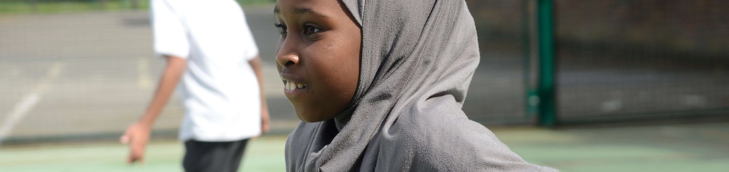 Girl in Hijab running in a playground